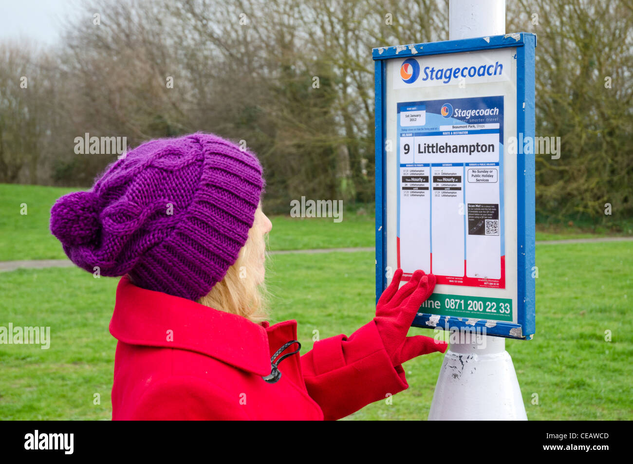 Dame à la recherche à un certain nombre de diligences 9 horaires de bus en Angleterre, Royaume-Uni. Banque D'Images