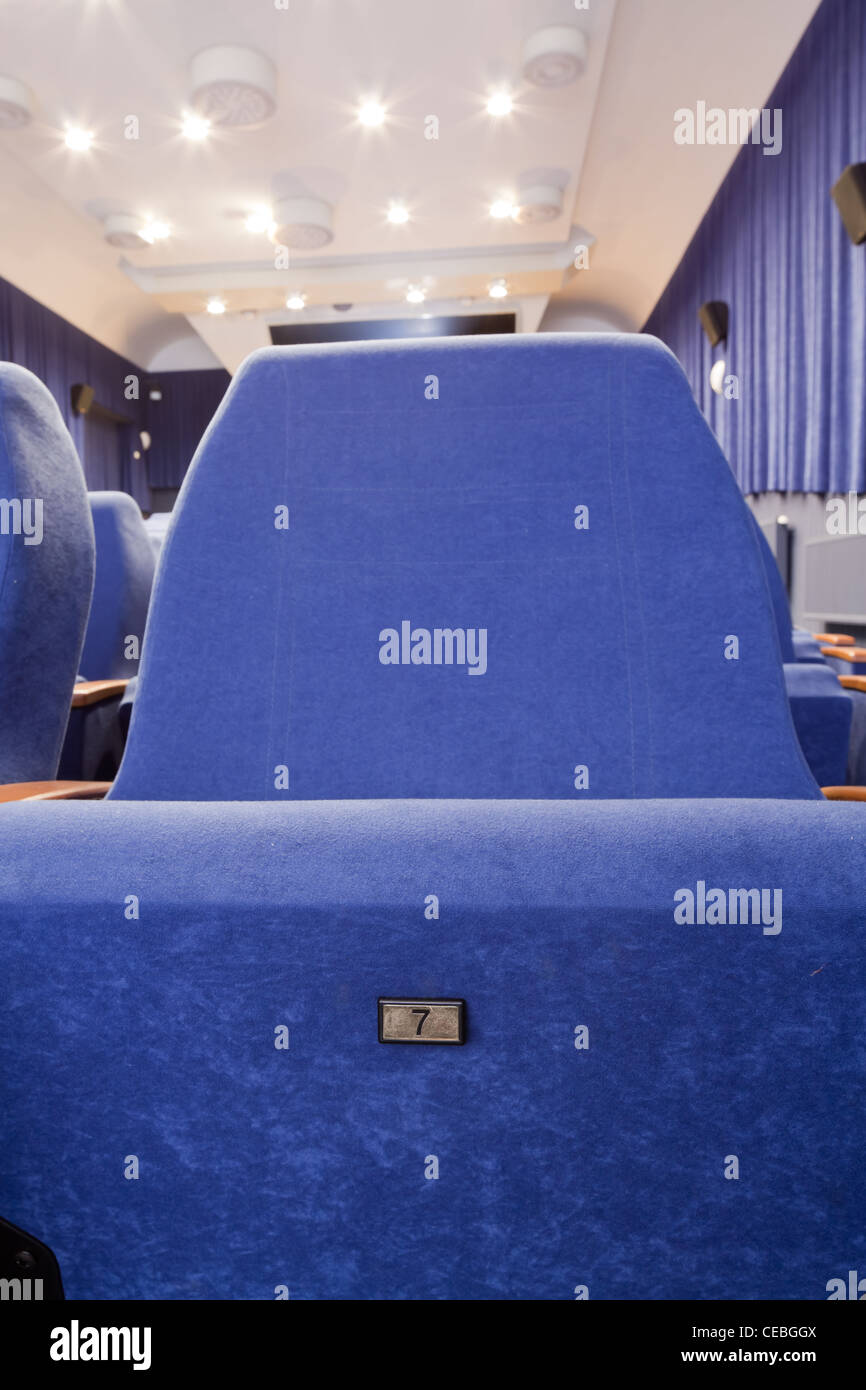 Salle de cinéma vide avec la première ligne de chaises et siège numéro sept. Banque D'Images