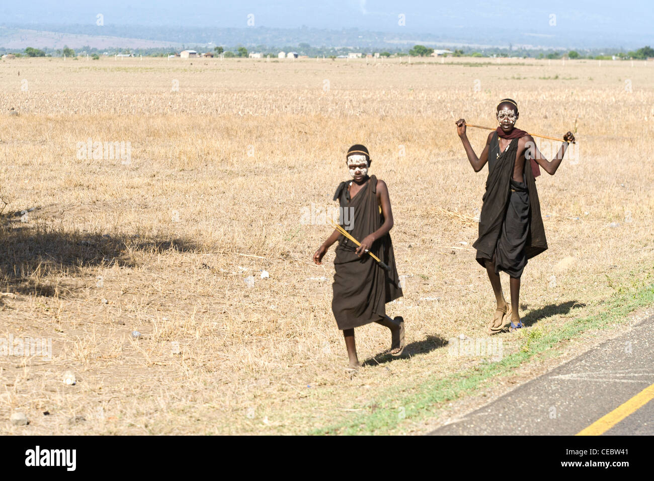 Les jeunes initiés Masai marcher le long d'une route à Arusha en Tanzanie Banque D'Images