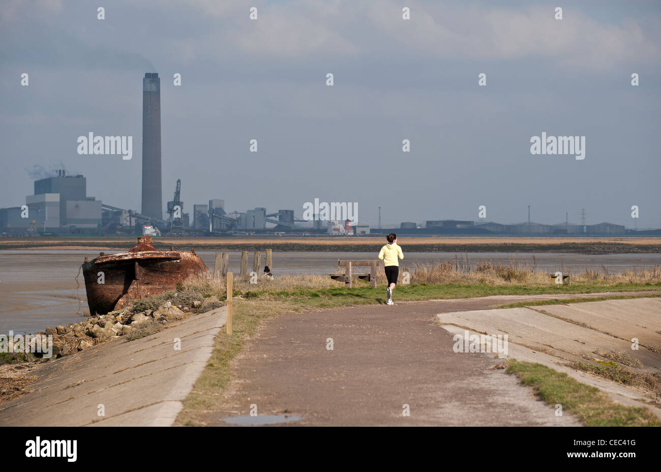 Une femelle le jogging le long d'un chemin sur les rives de l'estuaire de la Medway Banque D'Images