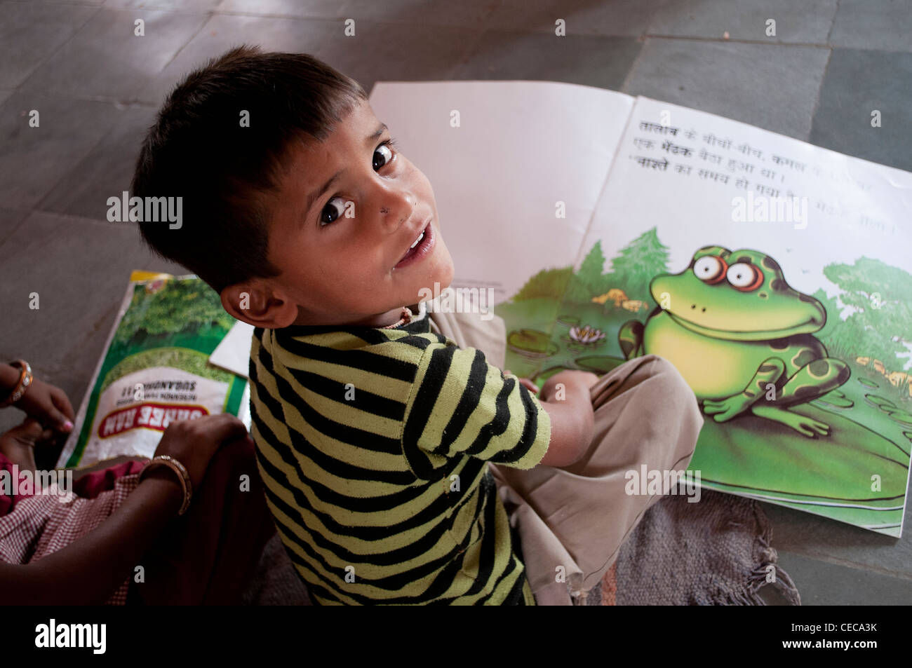 Petit garçon avec un gros livre, école du village près de Jaipur, Rajasthan, Inde Banque D'Images
