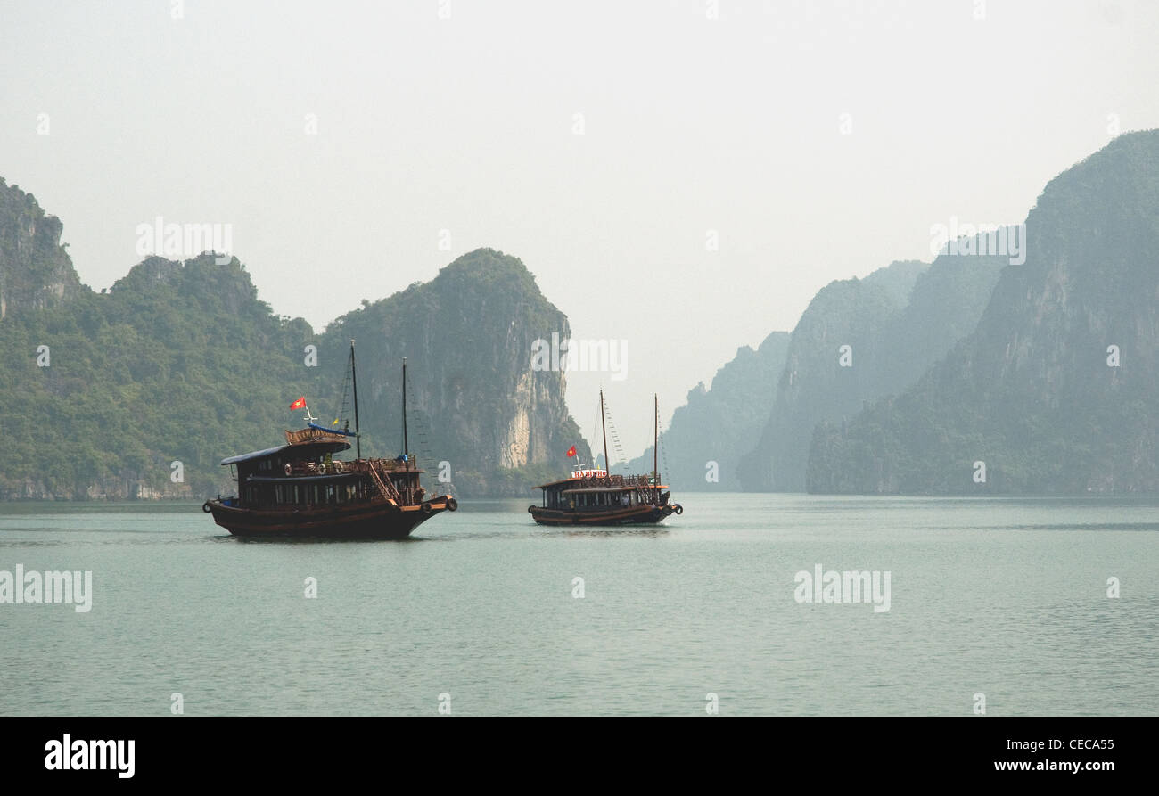 Au Vietnam, Ha Long Bay deux jonques converti en pause entre les eaux turquoise pâle caractéristique du Bay tours calcaires Banque D'Images