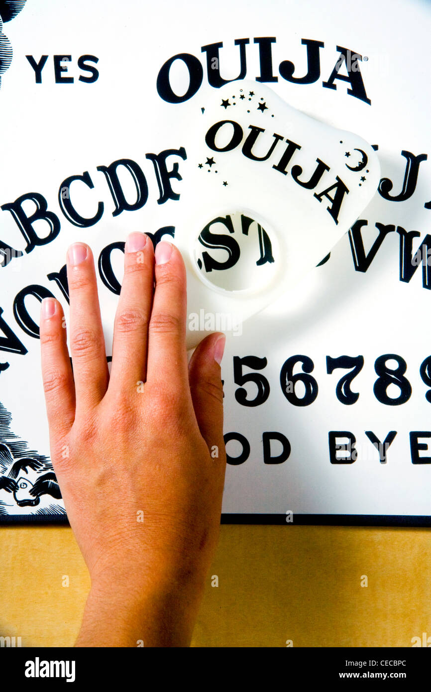 La main d'un jeune adulte les diapositives d'un Ouija board plaquet Banque D'Images