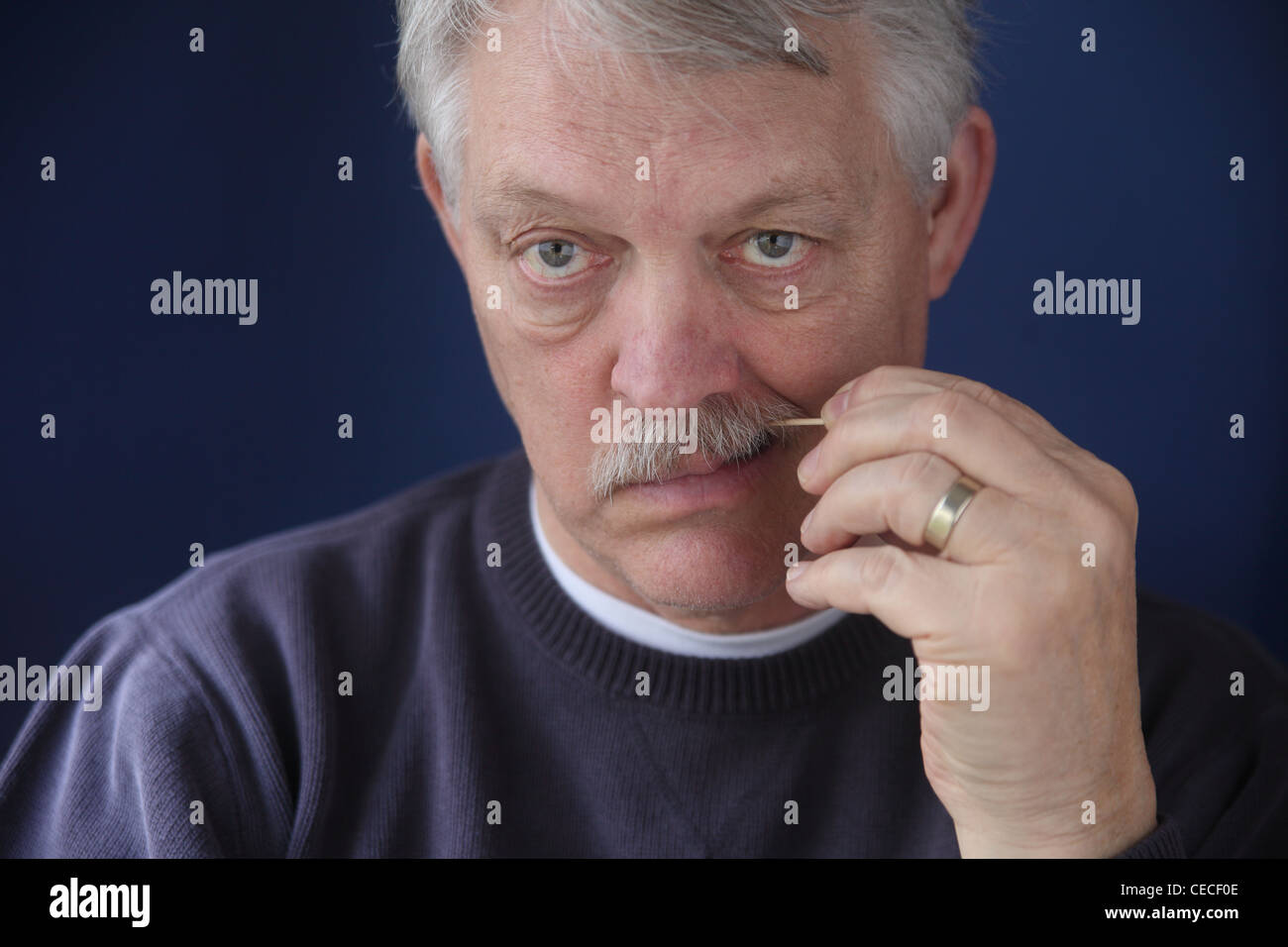 Homme plus âgé se nettoie les dents avec un cure-dent Banque D'Images