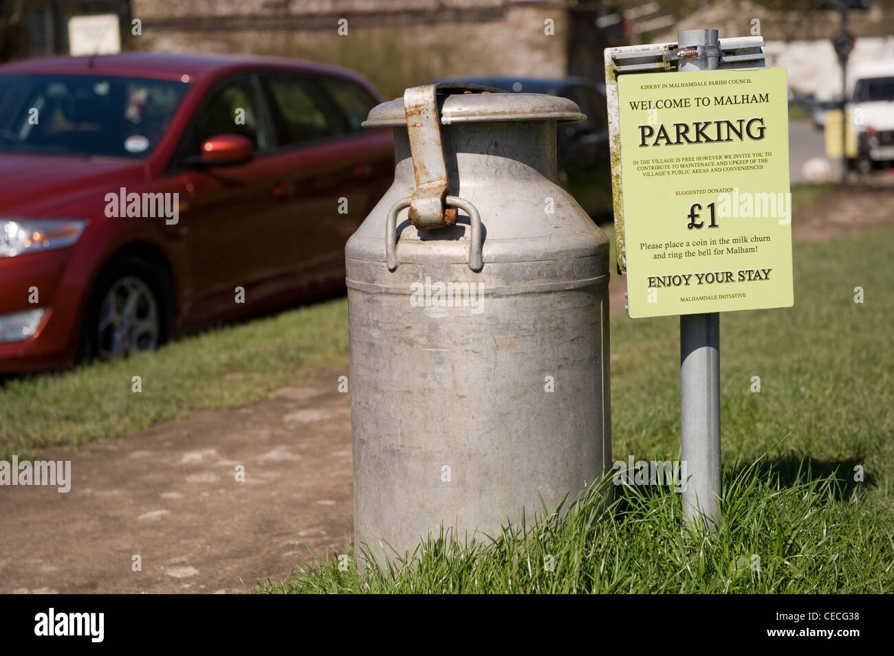 Style vintage ancien bidon de lait (utilisé pour collecter de l'argent) par bienvenue & paiement parking (£1) frais de parking - Malham, Yorkshire, Angleterre, Royaume-Uni. Banque D'Images