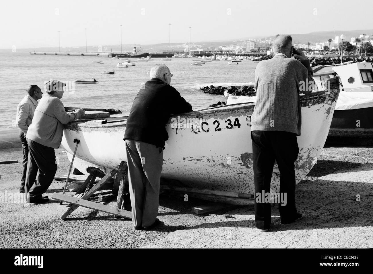 Personnes âgées homme debout contre un bateau dans le port de Puerto Del Rosario - Fuerteventura. Banque D'Images
