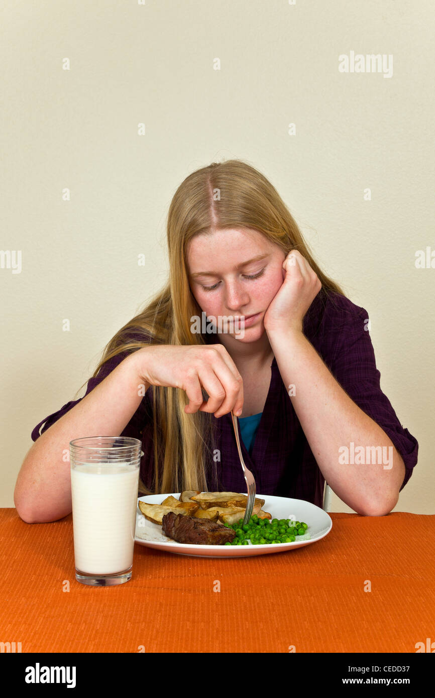 Californie volonté têtu de te morfondre moody woman at table Young Caucasian 13-16 ans ans n'aime pas jouer la nourriture ne mangent pas son dîner © Myrleen Pearson Banque D'Images