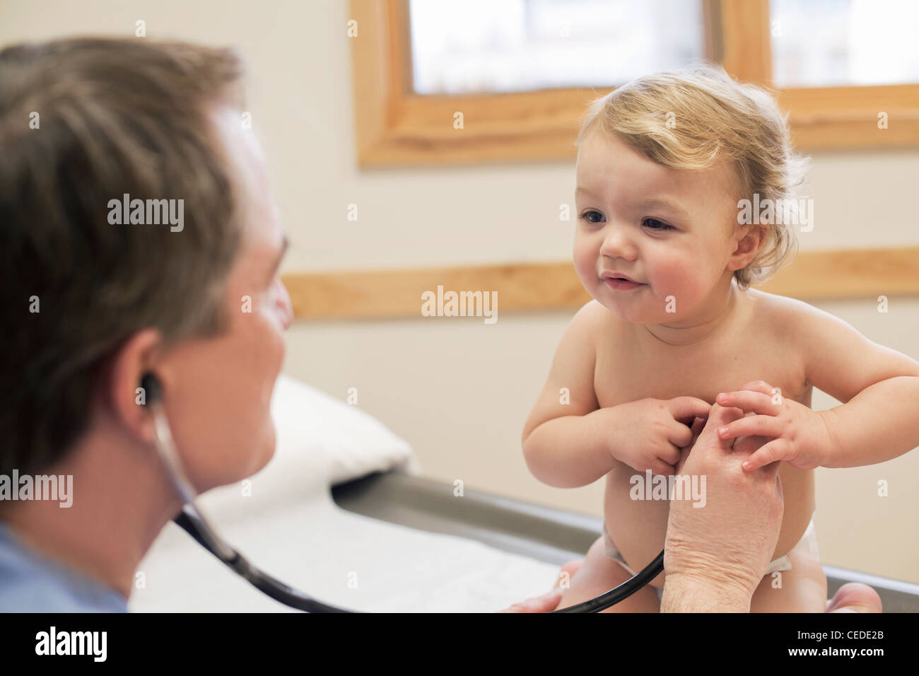 Médecin à l'écoute de bébé garçon's heart pendant l'examen. Banque D'Images