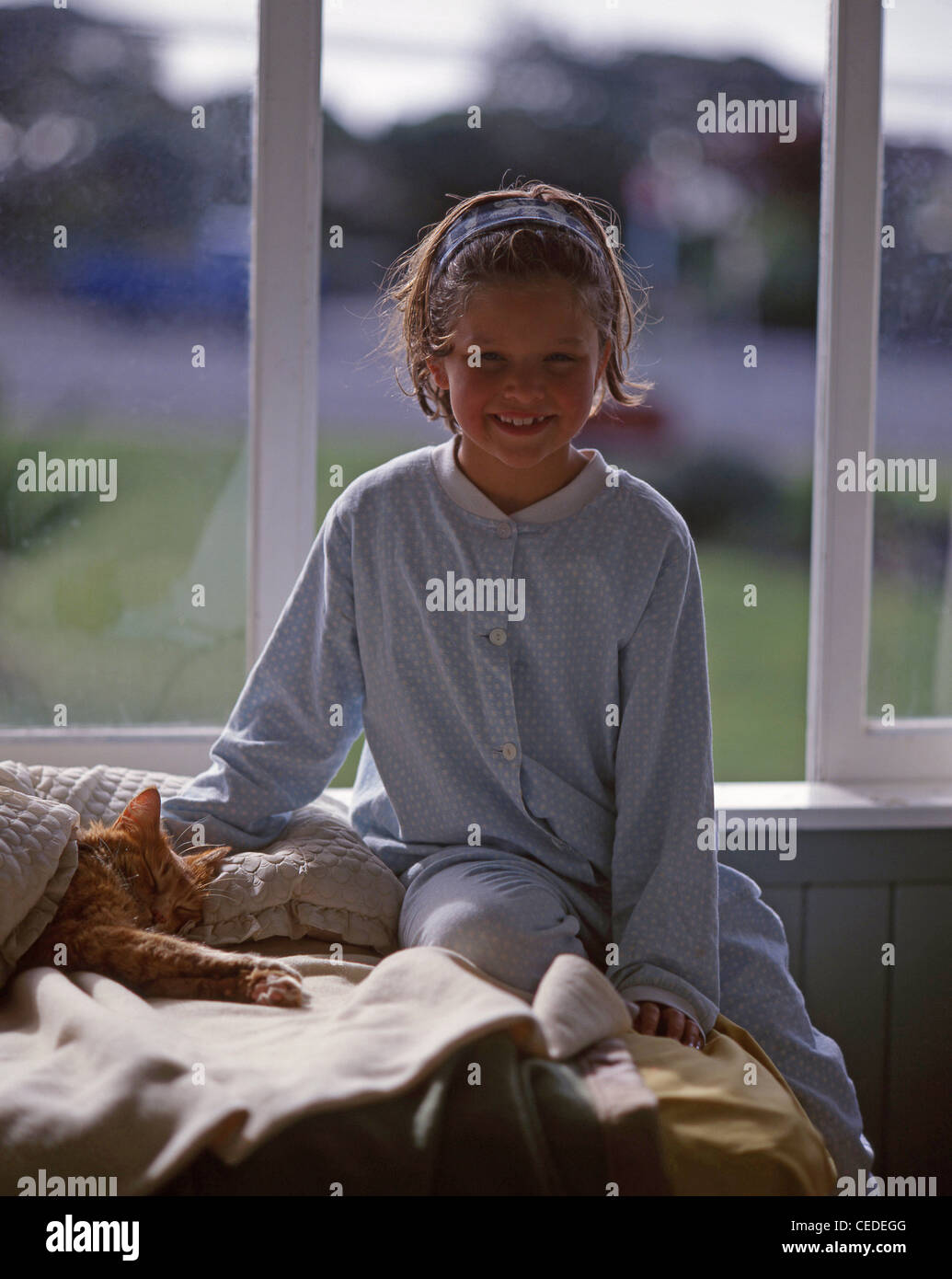 Young Girl wearing pajamas sitting on bed, Christchurch, Canterbury, île du Sud, Nouvelle-Zélande Banque D'Images