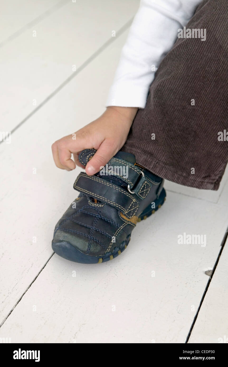 La main du garçon chaussure fixation, Close up Banque D'Images