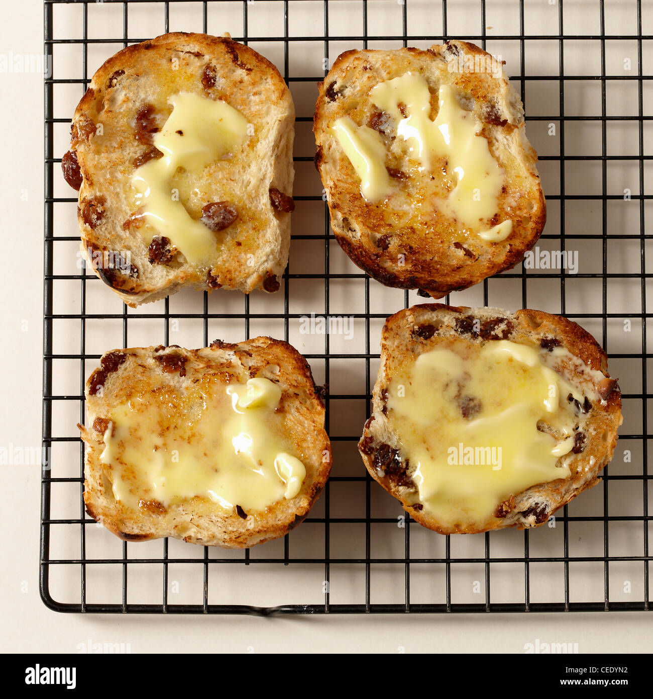 Quatre grillé au beurre les brioches sur une grille Banque D'Images