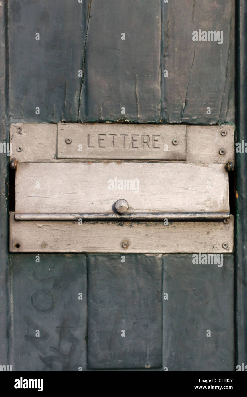 Une boîte aux lettres de couleur d'or sur une porte en bois Banque D'Images