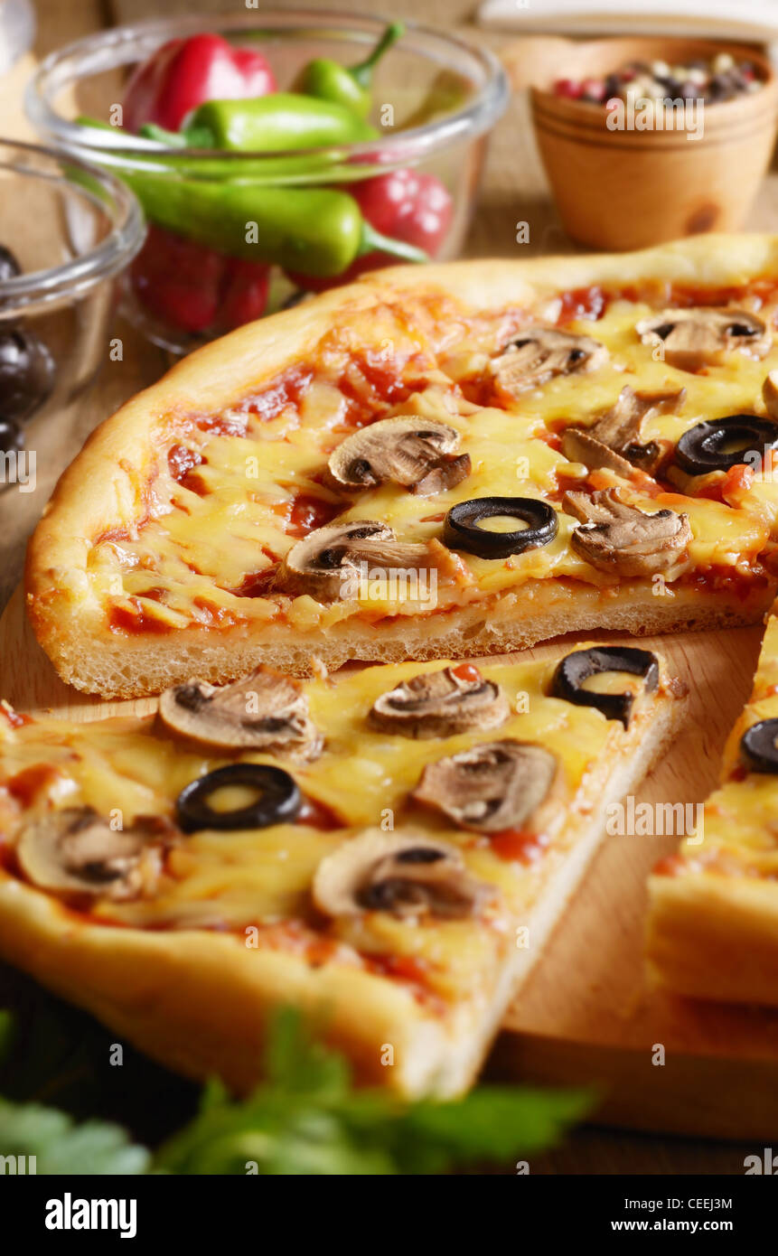 Pizza végétarienne aux champignons sur la table de la cuisine avec les verts et épices Banque D'Images