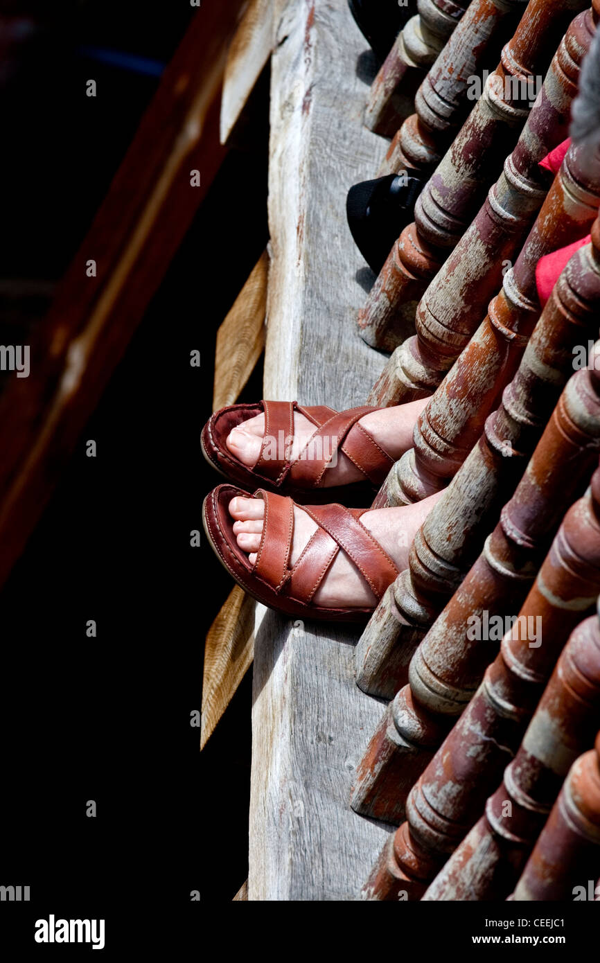 Les pieds d'un membre de l'assistance en sandales sur une journée ensoleillée au Globe Theatre London England Banque D'Images