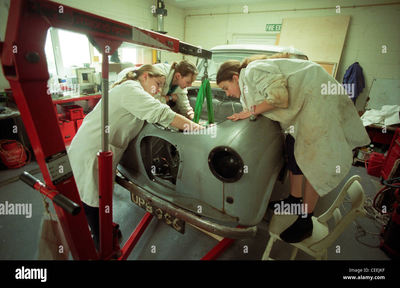 L'apprentissage de l'entretien voiture écolières dans un atelier. Banque D'Images