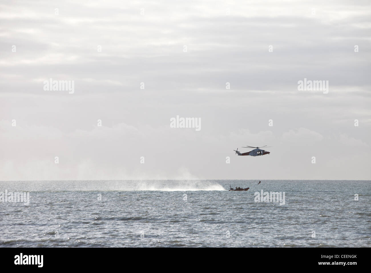 La pratique de garde-côtes de la RNLI depuis un hélicoptère de sauvetage d'un bateau en mouvement et tout près de la côte de Brighton, East Sussex, Angleterre Banque D'Images