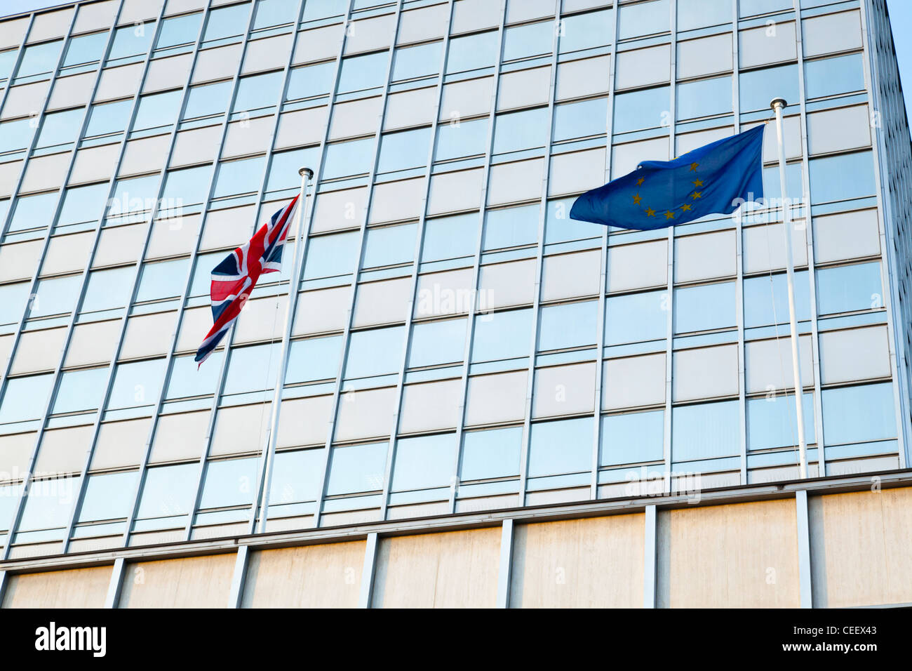 UK Drapeau et drapeau de l'UE battant ensemble. Union Jack et l'Union européenne drapeaux au vent à l'extérieur des bureaux à Nottingham, Angleterre, RU Banque D'Images