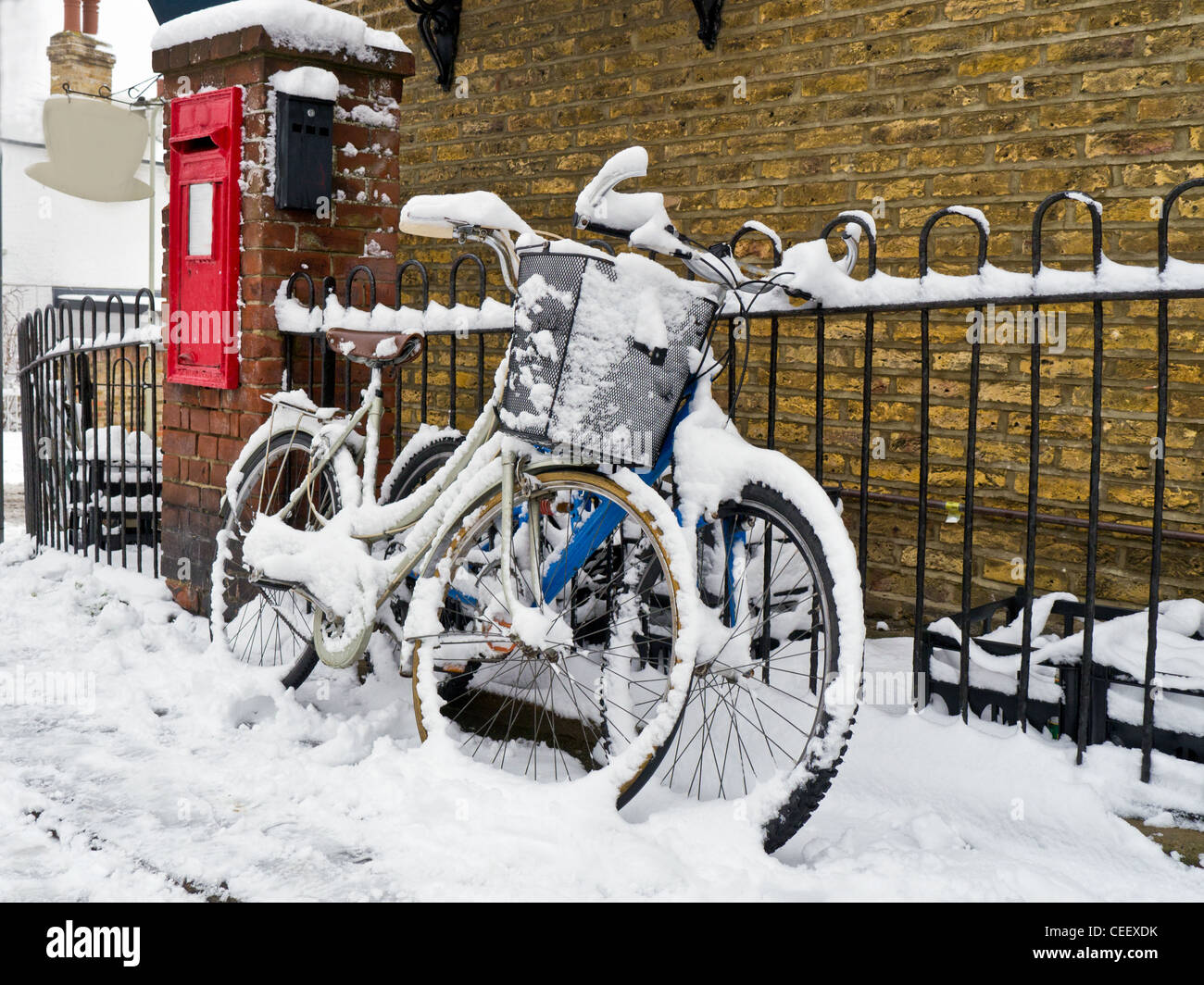 Des vélos dans la neige par une boîte postale. Banque D'Images