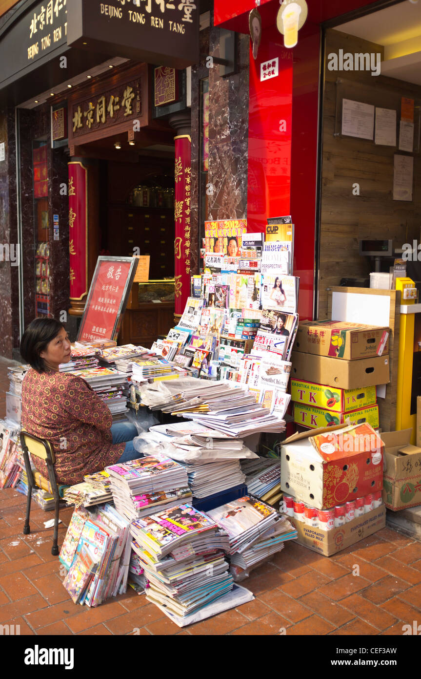 dh CAUSEWAY BAY HONG KONG une femme chinoise un kiosque vendeur de journaux se trouve sur le stand d'un vendeur de rue Banque D'Images