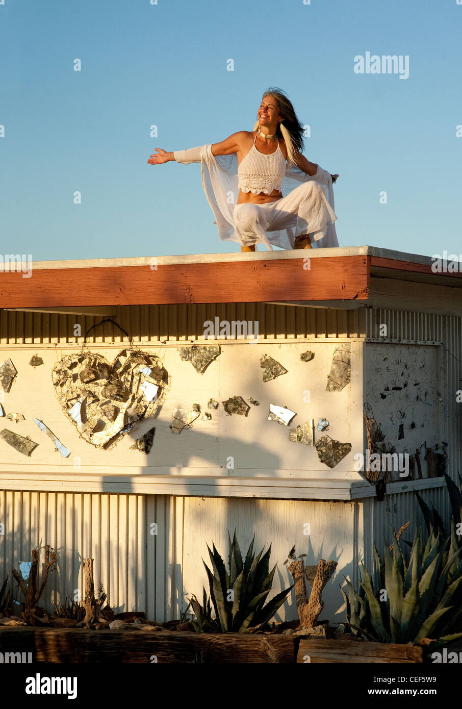 Femme holistique sur le toit d'une habitation peu arty funky. Banque D'Images