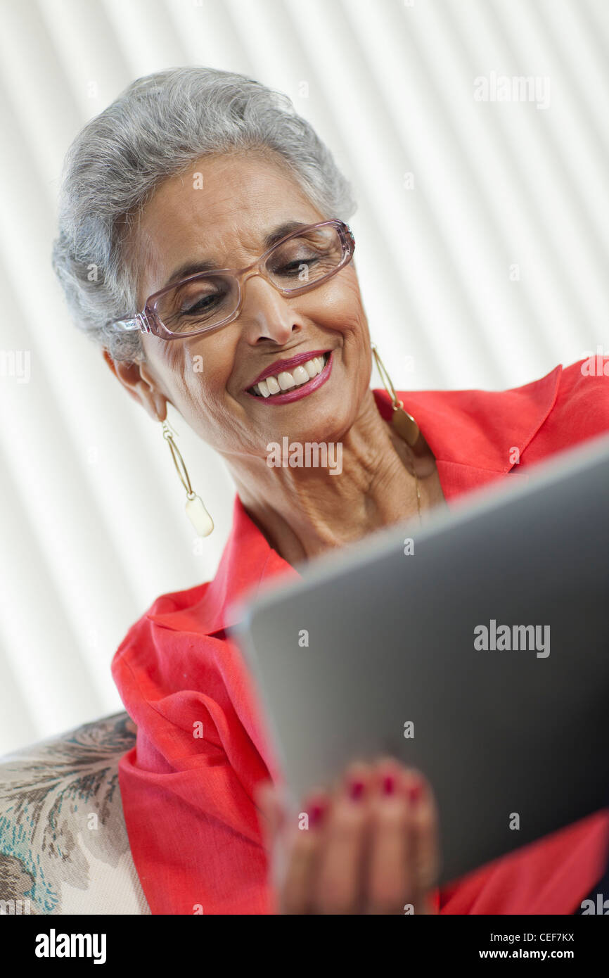 Hauts élégant black woman using a digital tablet Banque D'Images