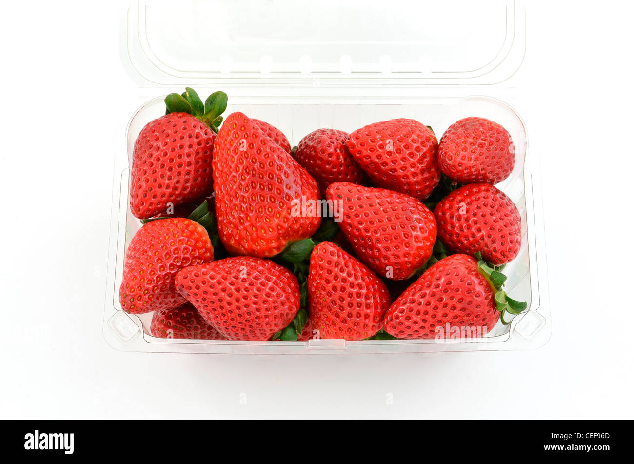 Fraises fraîches dans un contenant de plastique clair sur fond blanc en format horizontal avec prix pour copier Banque D'Images