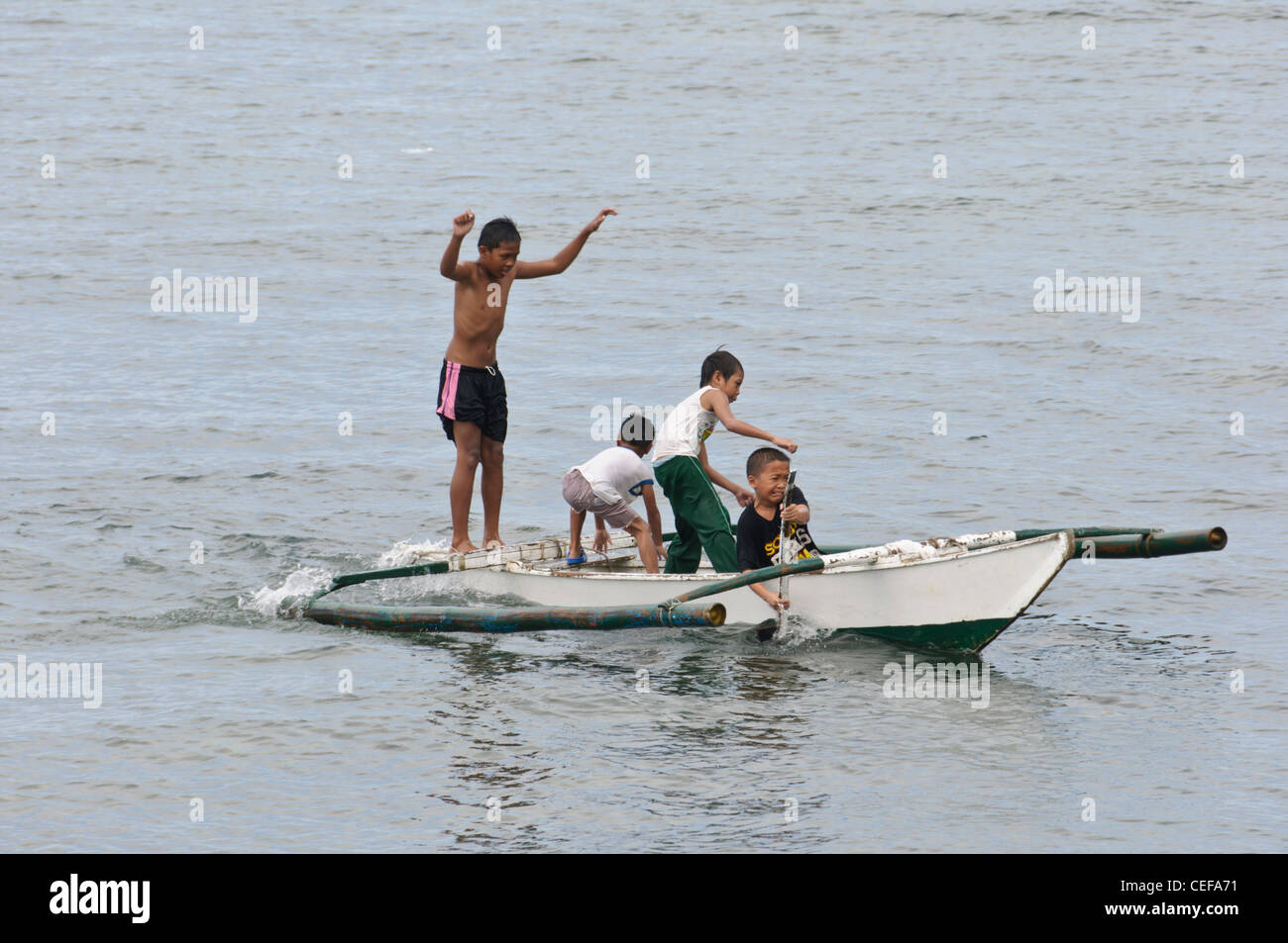 Quatre garçons philippins asiatiques avec petit bateau outrigger aviron  Photo Stock - Alamy