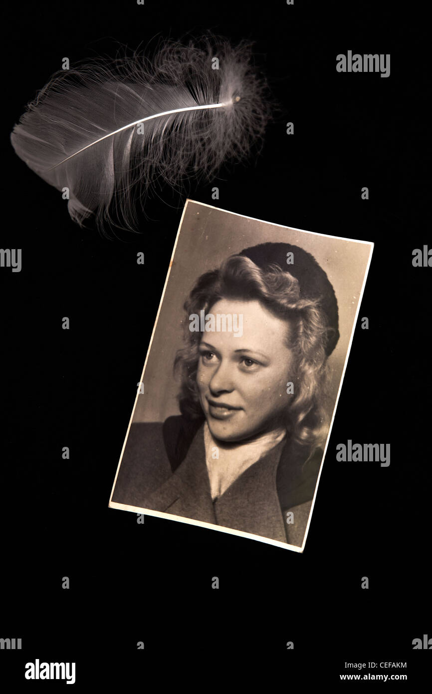 Une vieille photo d'une jeune femme des années 40 avec une plume Banque D'Images