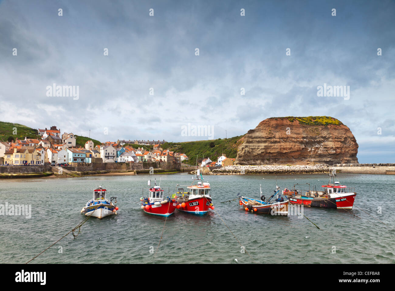 Bateaux de pêche dans le port sur un jour de tempête à Staithes, North Yorkshire, Angleterre. Banque D'Images