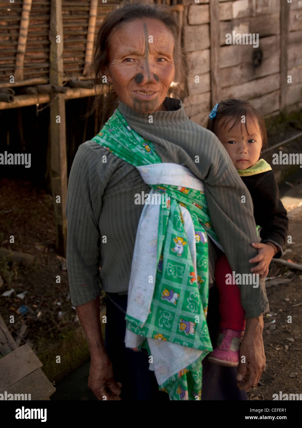 Une grand-mère de la tribu Apatani portant un enfant dans le porte-bébé traditionnel Banque D'Images