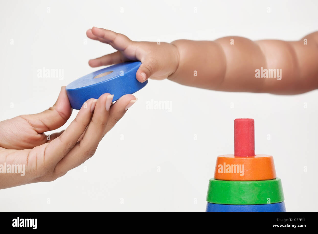 Main adultes donne un building block et bébé apprend à grip it Banque D'Images