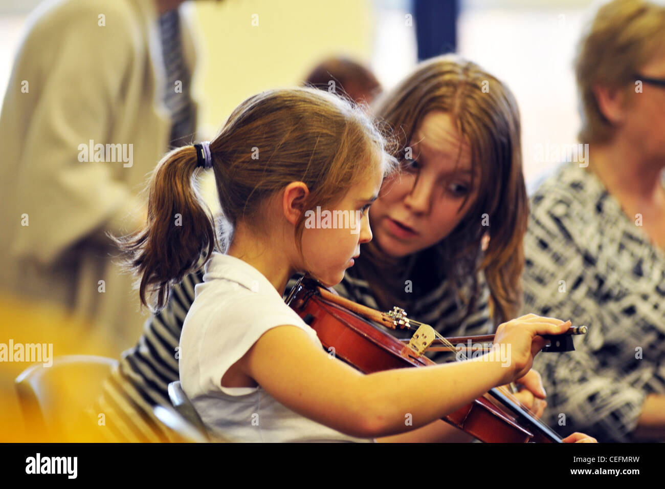 Professeur de musique donne cours de violon à 7 ans, dans une école primaire Banque D'Images