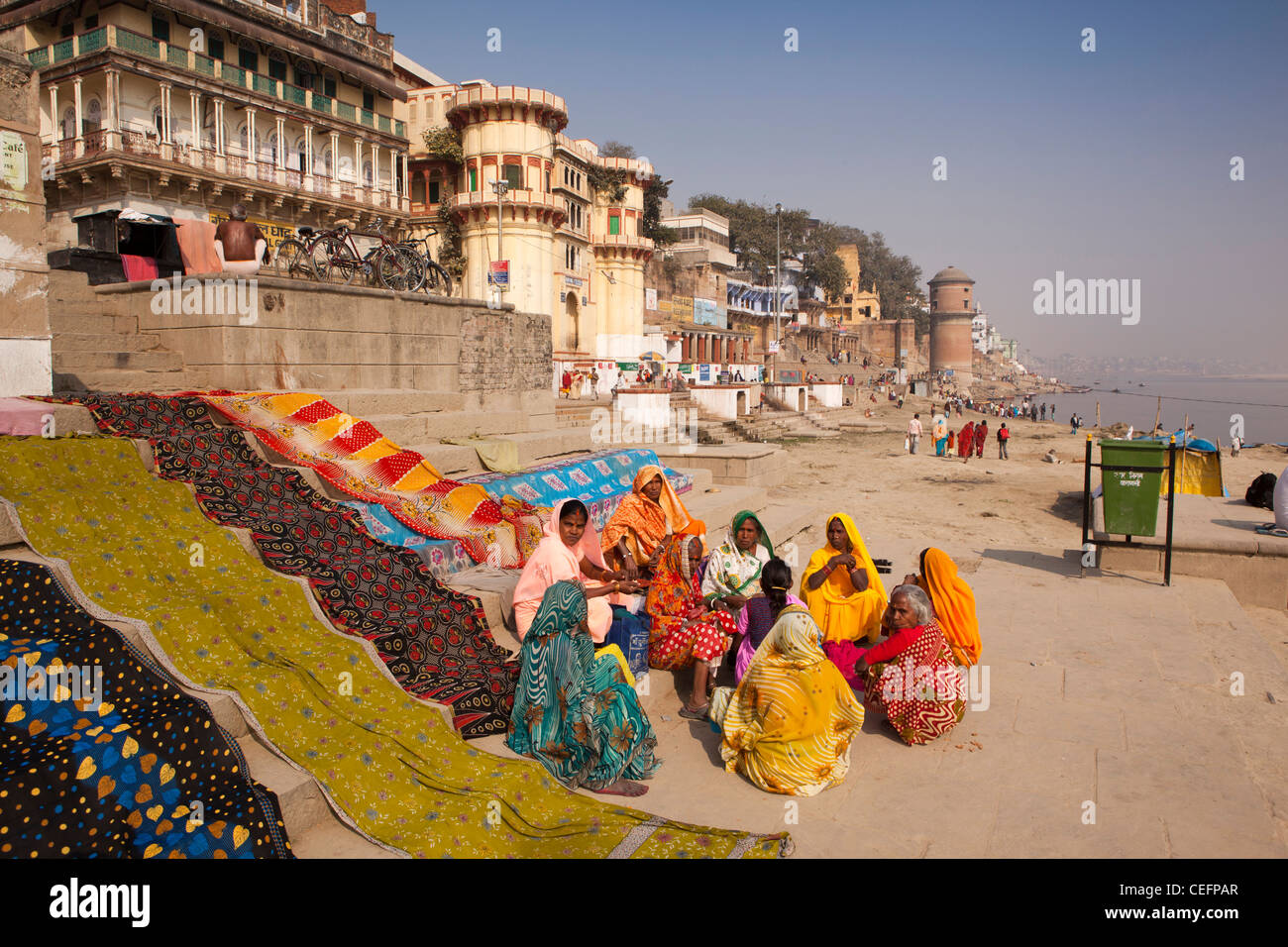 L'Inde, Uttar Pradesh, Varanasi, habillés de couleurs vives les pèlerins assis sur Reewal Ghat étapes ci-dessous Ganga Mahal Banque D'Images