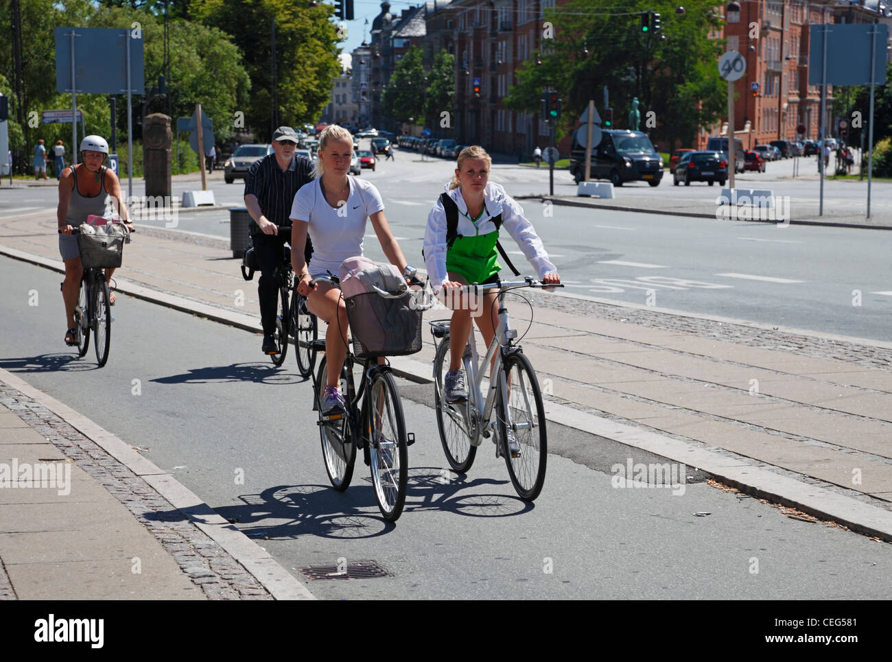 Les filles à vélo à Copenhague, au Danemark, sur l'une des nombreuses pistes cyclables le long des rues - à la gare Østerport, à Oslo Plads. Banque D'Images