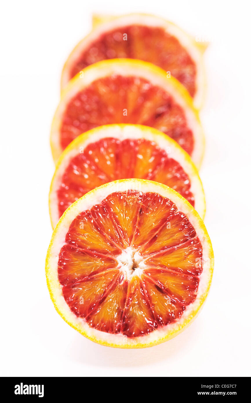 Citrus x sinenesis. Les moitiés d'orange sanguine sur fond blanc. Banque D'Images