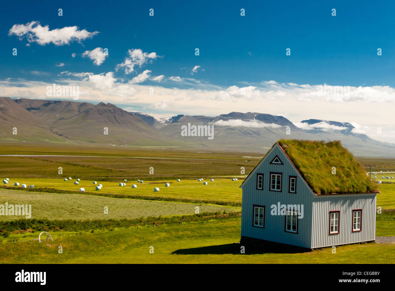 Ancienne ferme avec toit en mousse et paysage islandais typique. Banque D'Images