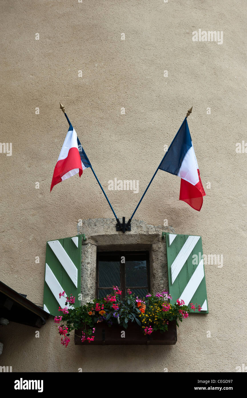 Fenêtre à volets avec drapeaux français en place de l'Eglise la place principale à Megève en France, en Europe Banque D'Images