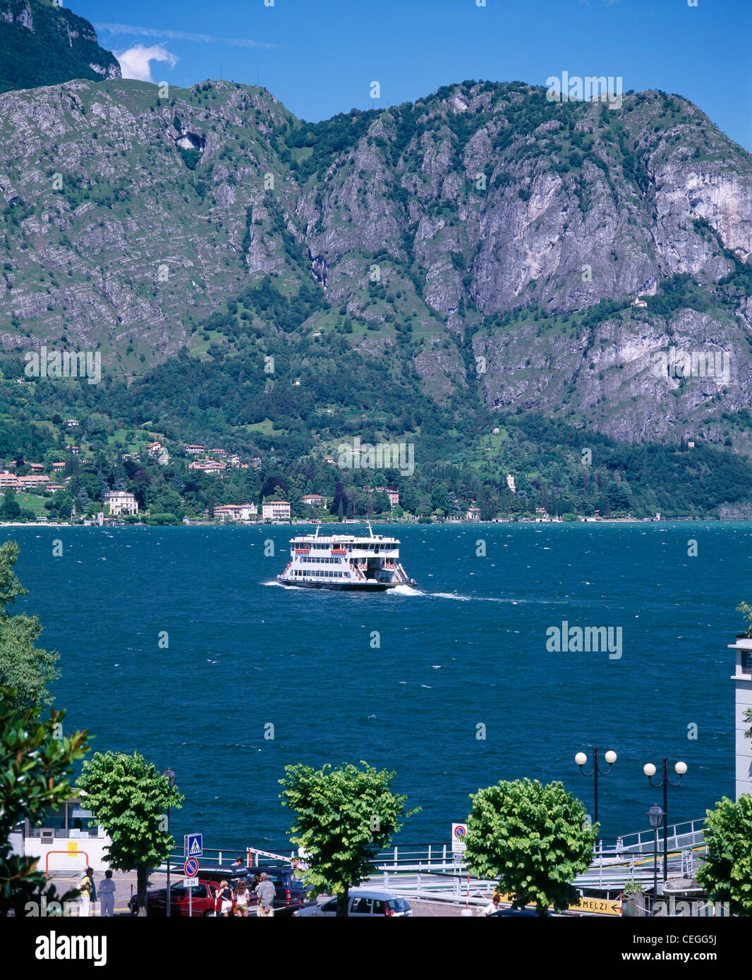Un traversier sur le lac de Côme, Bellagio de passage à Cadenabbia., Lombardie, Italie. Derrière est la colline rocheuse de Sasso San Martino. Banque D'Images Un traversier sur le lac de Côme, Bellagio de passage à Cadenabbia., Lombardie, Italie. Derrière est la colline rocheuse de Sasso San Martino. Banque D'Images