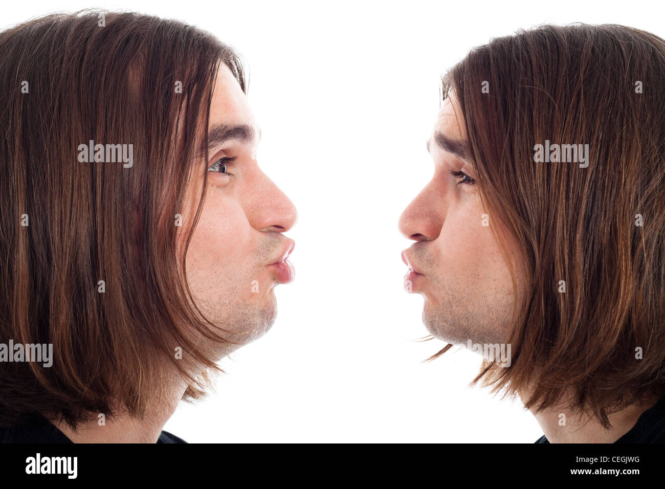 Adulte de jeune homme aux cheveux long baiser faisant face, isolé sur fond blanc. Banque D'Images