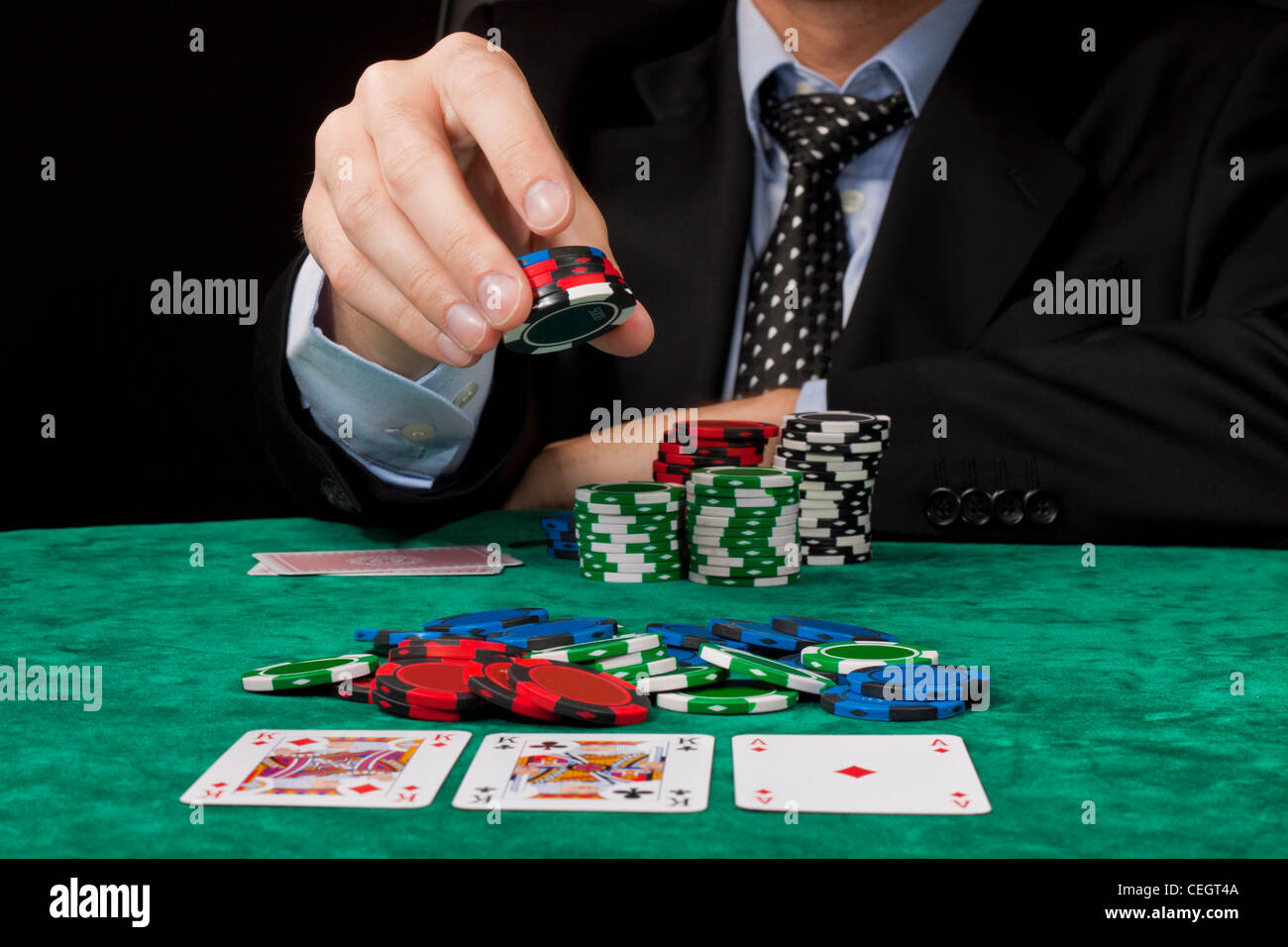 Un homme d'affaires placer un pari dans un Texas hold 'em poker jeu. Banque D'Images