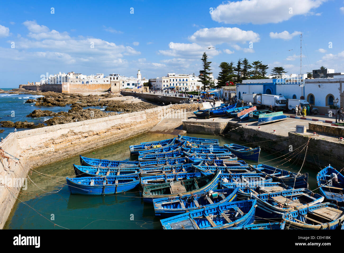 Vue sur la vieille ville depuis les murs de la Skala du port avec bateaux de pêche locaux dans l'avant-plan, Essaouira, Maroc Banque D'Images