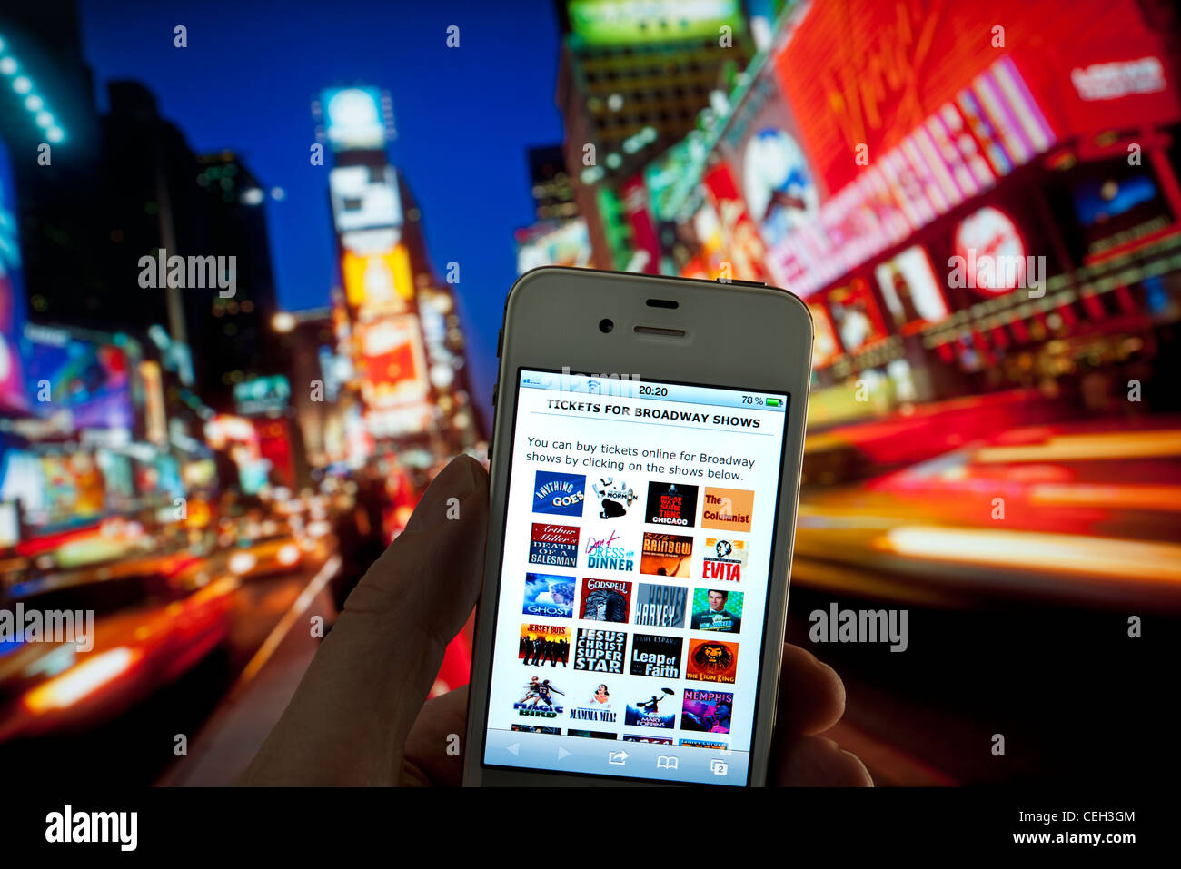L'iPhone d'Apple au crépuscule avec écran pour l'affichage en direct sur l'achat de billets en ligne pour les spectacles de théâtre de Broadway Times Square New York USA Banque D'Images