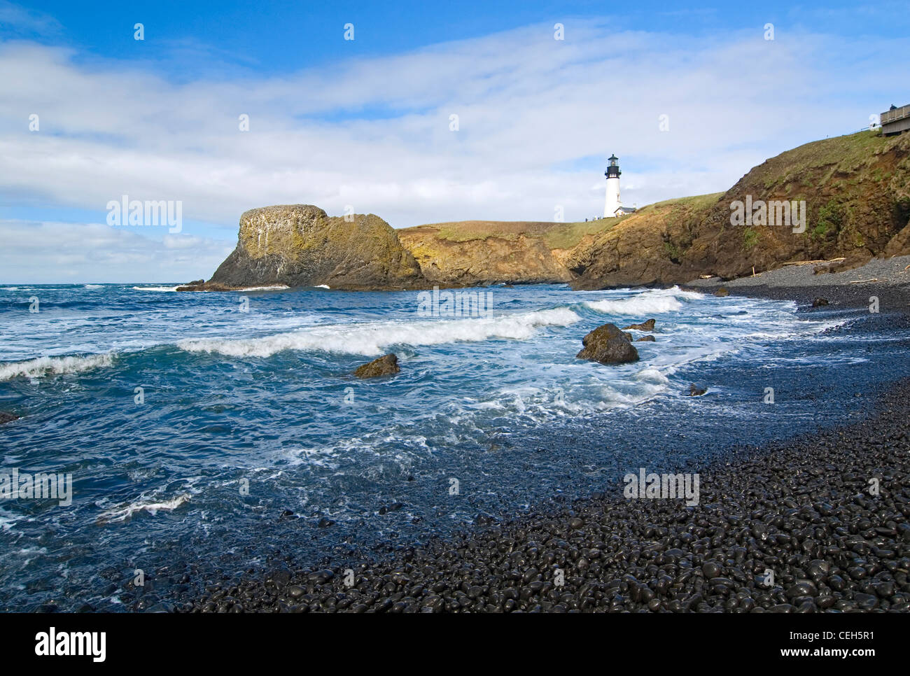 Yaquina phare sur le haut de plage de rochers. Banque D'Images