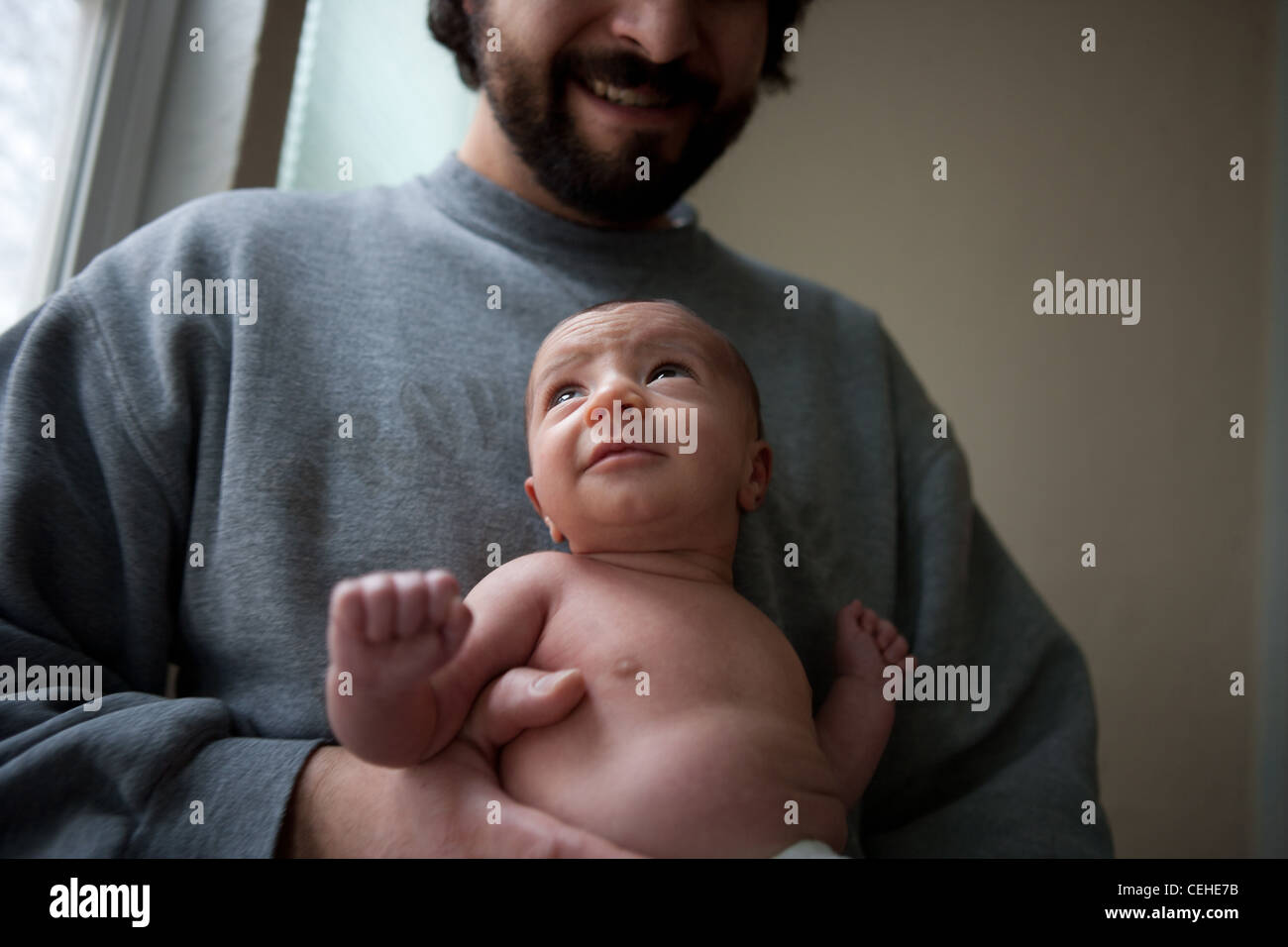 Deux mois et demi jusqu'à la petite fille, qui a eu lieu par le père à la maison. Banque D'Images
