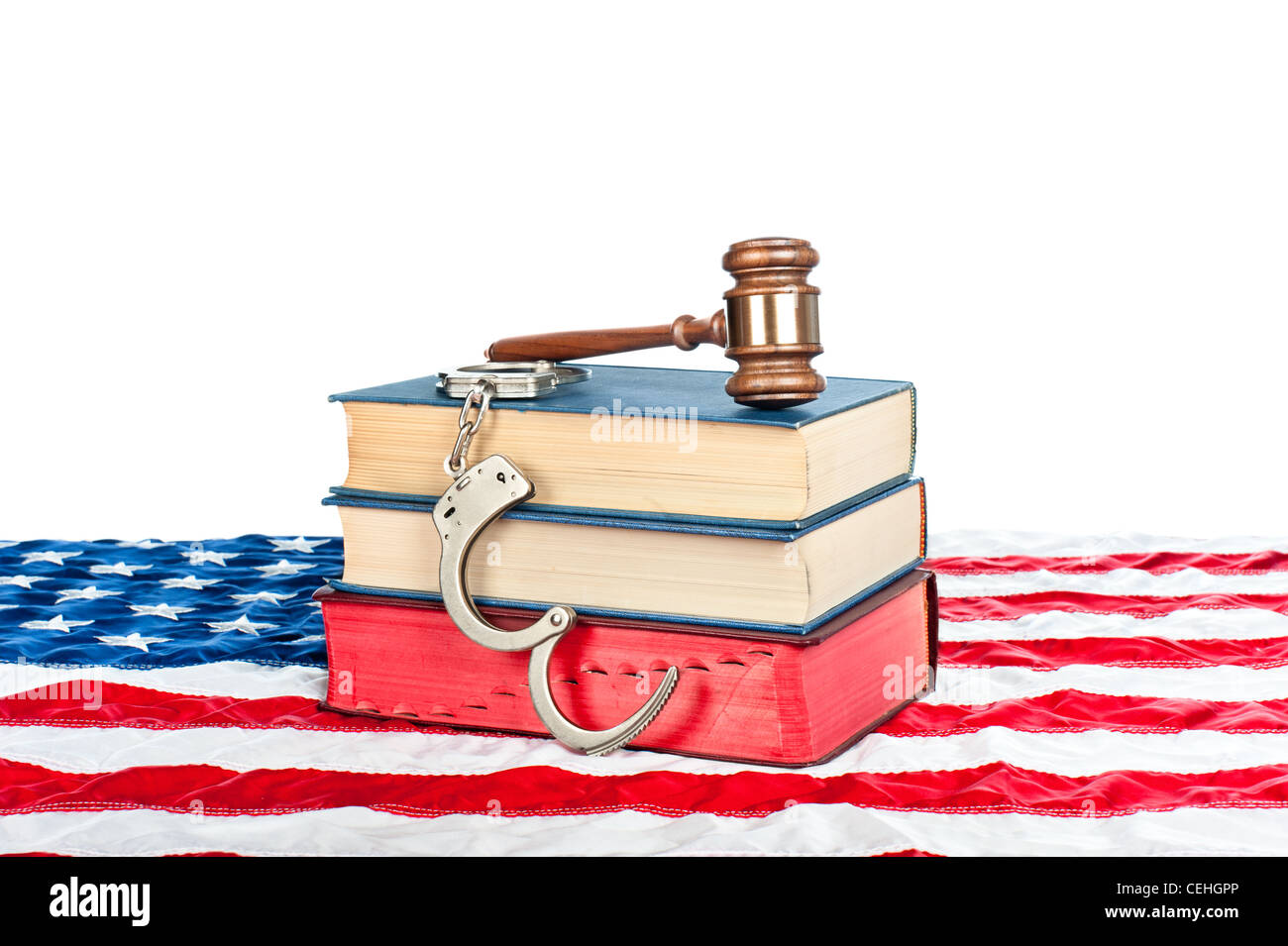 Gavel, ouvrages de droit et des menottes reposant sur un drapeau américain avec un fond blanc pour le placement de l'exemplaire. Banque D'Images