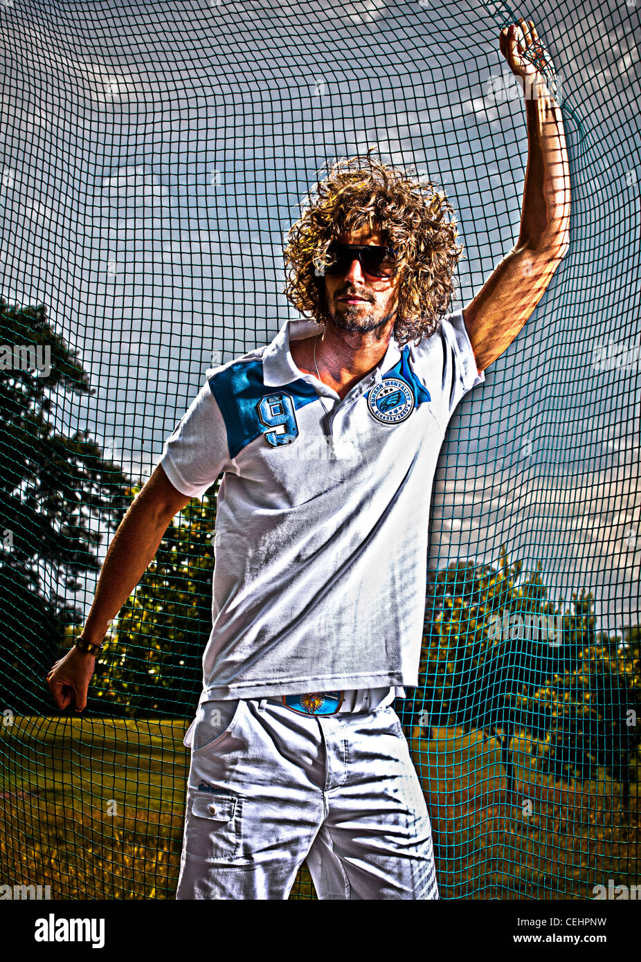 Un noir et blanc et couleur photographie d'un homme blanc,20-25 ans vêtu de vêtements de golf à la mode sur un practice de golf. Banque D'Images