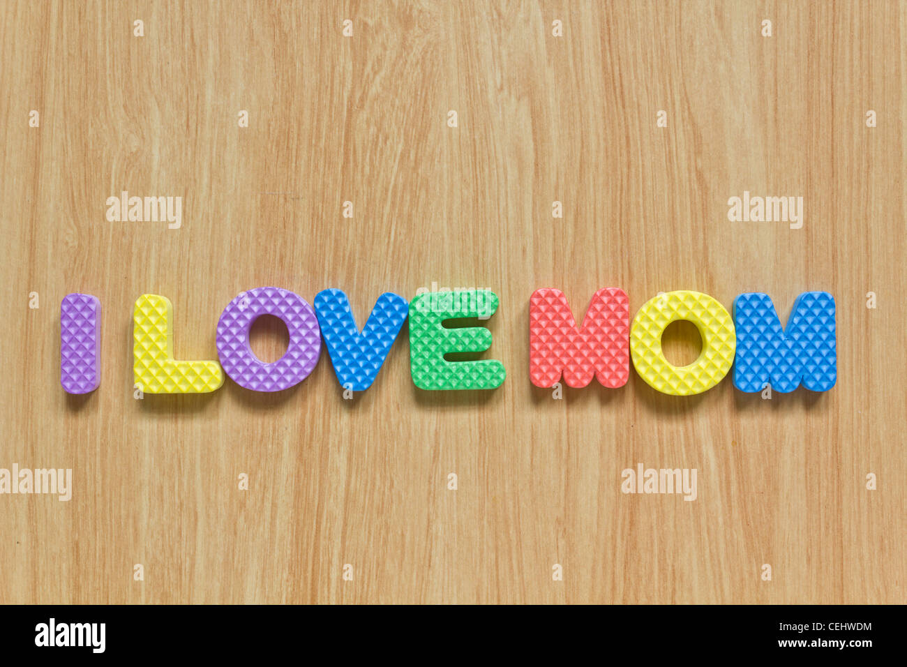 Lettres colorées avec 'J'aime maman" isolé sur la texture du bois Banque D'Images