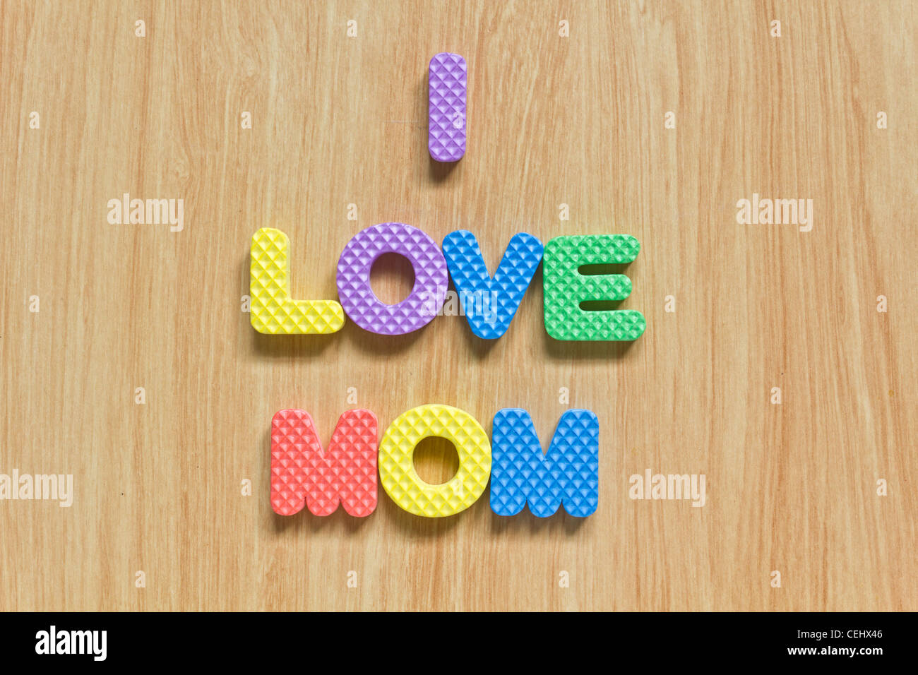 Lettres colorées avec 'J'aime maman" isolé sur la texture du bois Banque D'Images