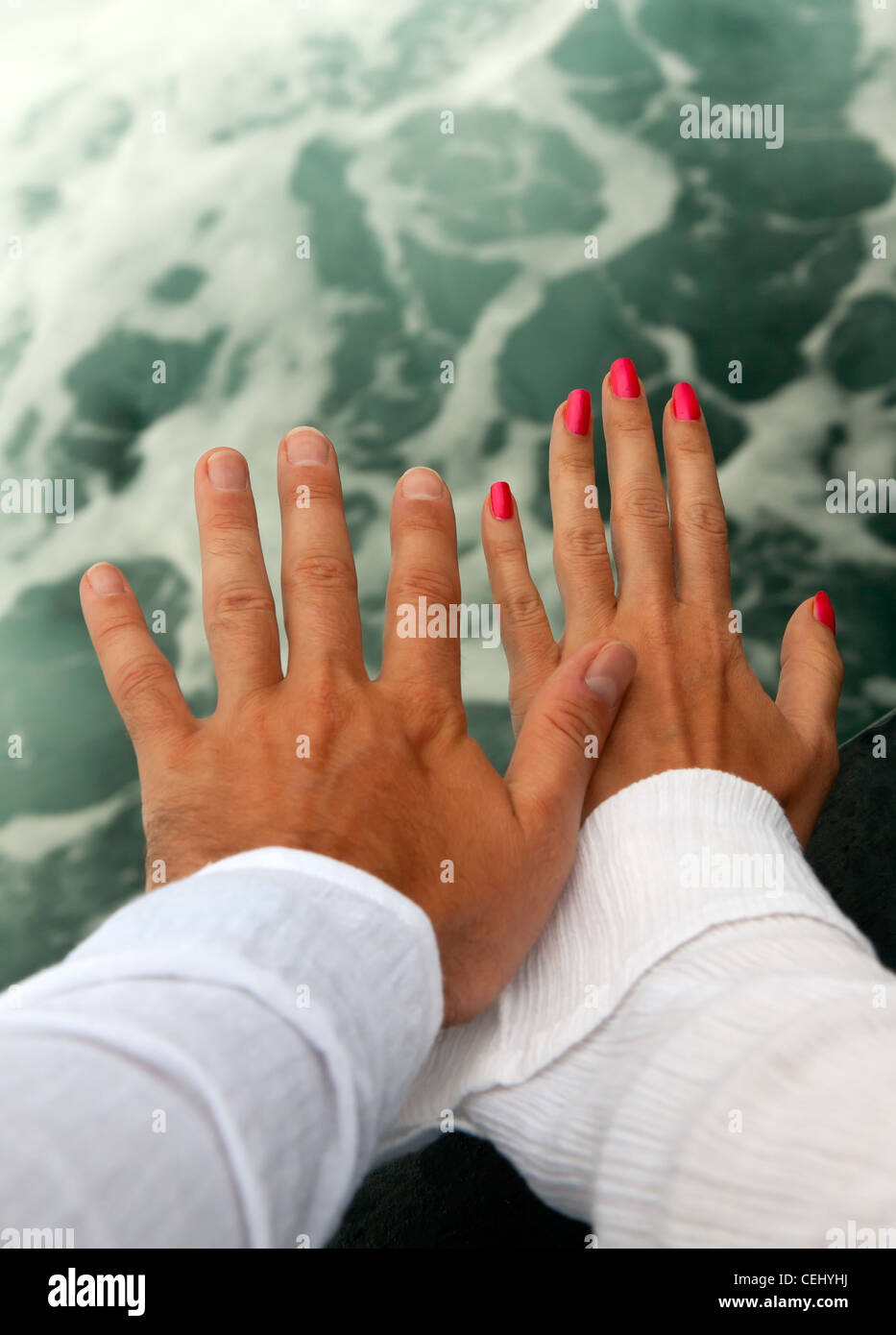 Les hommes et femmes, les mains tannées contre la mer en furie Banque D'Images