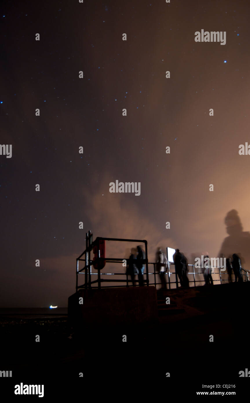 Astronomes en attente par la mer du Nord dans l'espoir de voir les aurores boréales Banque D'Images